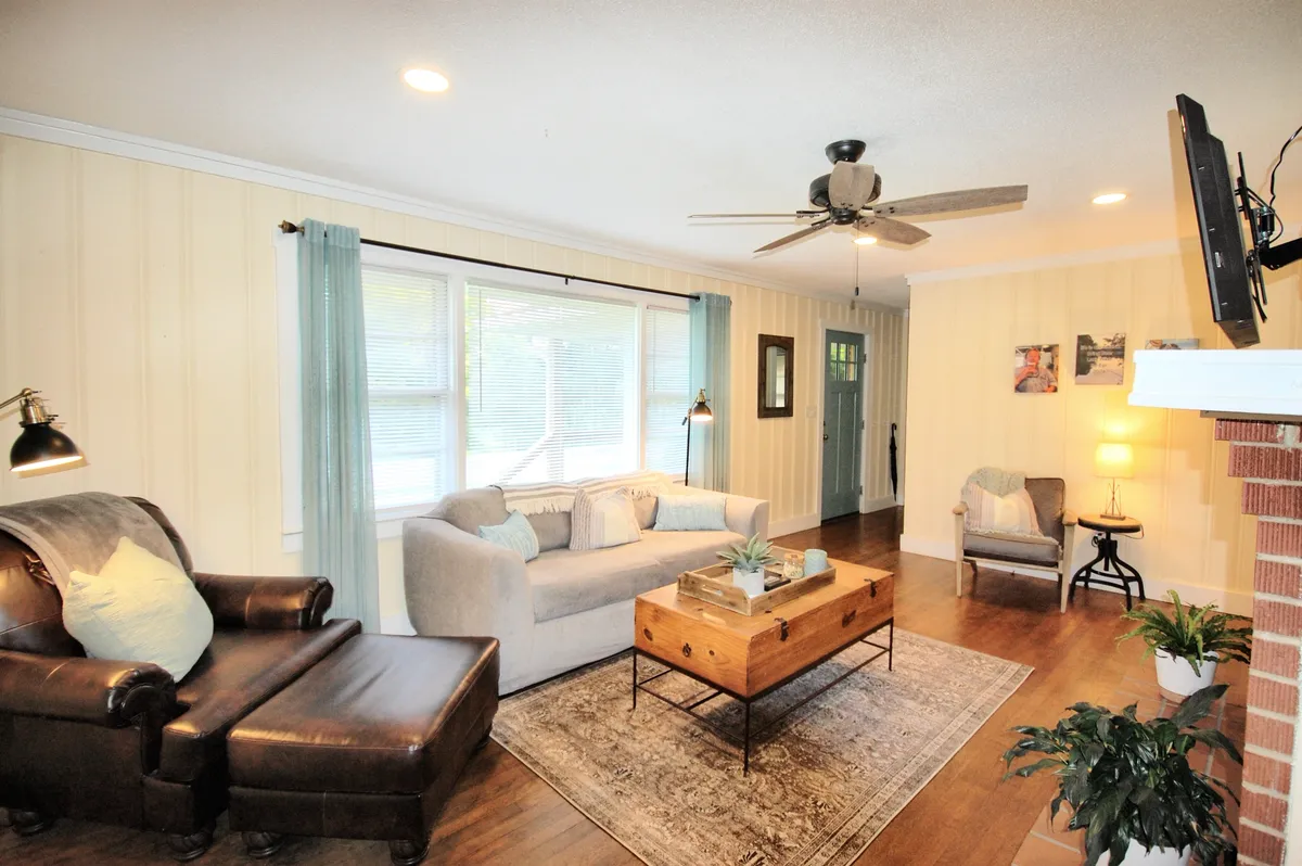 The living room features a comfortable sofa, a coffee table, an inviting armchair, and a window that fills the space with natural light. The setup encourages relaxation, socializing, or enjoying a quiet moment—ideal for couples, families, or solo travelers.
